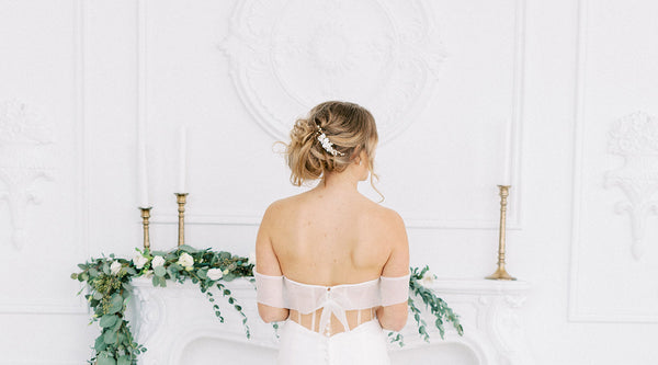 bride standing at mantle with greenery and candlesticks