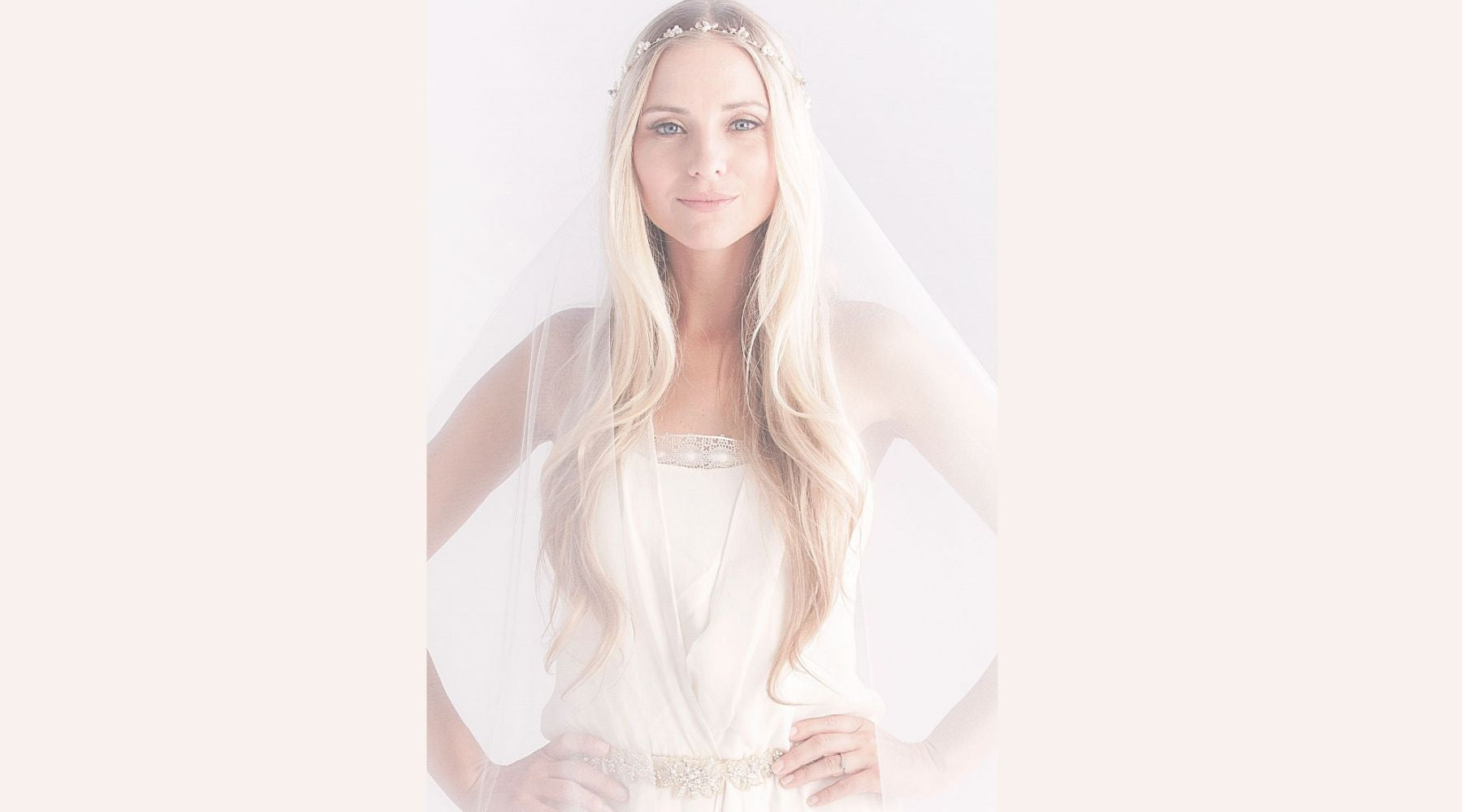 smiling bride wearing a headpiece a veil and a belt