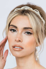 woman with hand to cheek wearing modern pearl crystal chain drop earrings by Laura Jayne