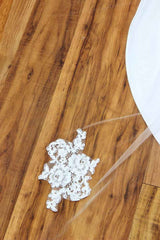 The drama of a drop veil meets the romance of lace appliques that seemingly "float" through this chapel length Alencon lace bridal veil.