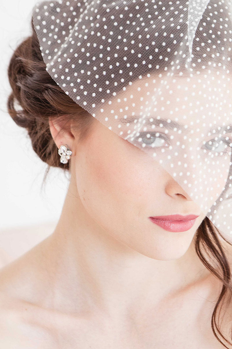 Woman wearing dotted face veil and Laura Jayne pear crystal pearl post earrings.