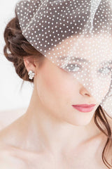 Woman wearing dotted face veil and Laura Jayne pear crystal pearl post earrings.
