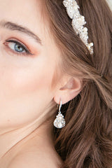 Partial facial view of woman with pearl crystal teardrop earring