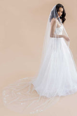 Full length view of a modern romantic bride wearing a long, sheer, cathedral length wedding veil with beaded flower blossoms on the sides and train. Monet Beaded Blossom Cathedral Veil by Laura Jayne Accessories Toronto. Made in Canada