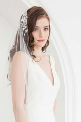 Bride wearing waltz length mantilla veil with hand embroidered flower motifs. Rosalie Mantilla Veil by Laura Jayne.