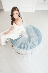 Edgy modern bride seated wearing a cool cathedral veil with ostrich feathers and pearls. Winona Cathedral Veil with Feathers. Made in Canada by Laura Jayne Accessories Toronto. 