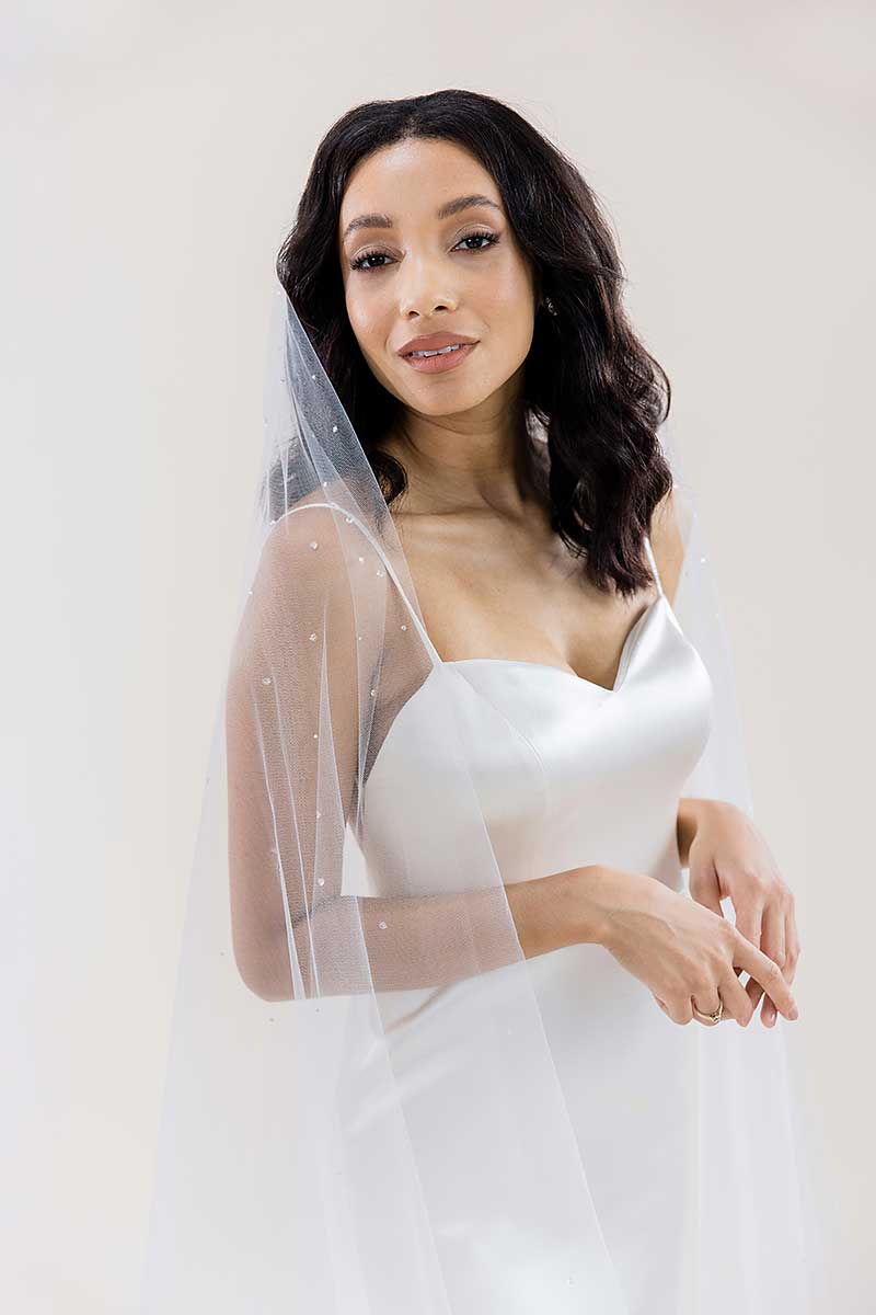 Side front of bride wearing a ballet cut crystal beaded waltz length drop wedding veil. Rain Crystal Waltz Length Veil by Laura Jayne Accessories Toronto.