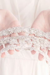 woman presenting wedding dress belts in hands