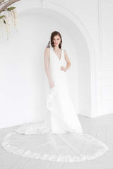Front view of the Peyton Mantilla Cathedral veil's full train on bride.