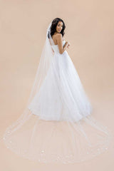 Back profile of bride wearing a cathedral length veil beaded with pearls and paillettes for added shimmer. Liliya Cathedral Veil by Laura Jayne Accessories Toronto.