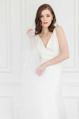 Bride with Liliya cathedral pearl beaded wedding veil draped over arm. Handcrafted in Canada by Laura Jayne Accessories Toronto.