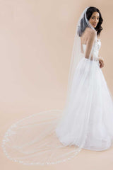 Side view of a classic, modern bride wearing an elegant cathedral length wedding veil with a delicate hand beaded floral border. Bisous Floral Cathedral Veil by Laura Jayne Accessories Toronto. Handmade in Canada.