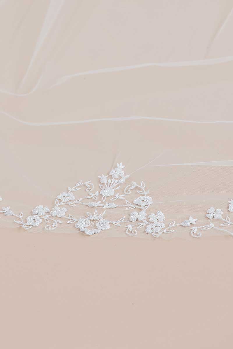 Close up view of the focal motif of hand-beaded flowers and vines at the centre of the train on our Bisous beaded cathedral bridal veil. Laura Jayne Accessories Toronto. Handcrafted in Canada.
