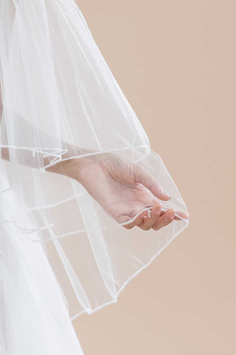 Close up of pearl and crystal detail along the border of the Jess Beaded Edge Fingertip Veil by Laura Jayne Accessories. Handcrafted in Toronto, Canada.