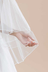 Close up of pearl and crystal detail along the border of the Jess Beaded Edge Fingertip Veil by Laura Jayne Accessories. Handcrafted in Toronto, Canada.