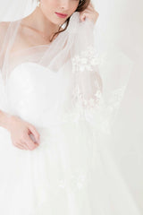 Modern bride wearing unique statement cathedral wedding veil with custom monogram and hand embroidered beaded flower appliques. Khrysia Monogram Cathedral Veil by Laura Jayne. Handmade in Toronto, Canada.