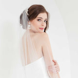 Modern romantic bride striking a pose wearing an ivory tulle hand beaded cathedral wedding veil with embroidered flowers and custom monogram. Khrysia Mondgram Cathedral Veil. Laura Jayne Accessories Toronto. Handcrafted in Canada.