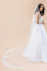 Side profile view of modern, minimalist bride wearing long, cathedral length veil with floral border and a sprinkle of pearls and crystals. Nera 3D Flower Cathedral Veil by Laura Jayne Accessories Toronto. Handcrafted in Canada.