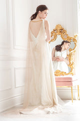 Full length view of the back of a modern bride wearing a statement cowl cathedral veil or cape with all-over glitter detail in rose gold color. Adryn Cathedral Cowl Veil Cape. Laura Jayne Accessories Toronto. Handcrafted in Canada.