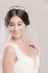 Front view of the hand embroidered floral detail at the crown and crystal edging on the Cerie Fingertip Juliet Veil by Laura Jayne. Made in Toronto, Canada.