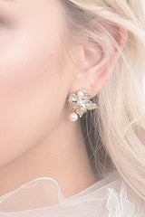 Gold leaf pearl drop earring close up on woman