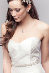Bride looking down wearing Verde silver leaf bridal sash by Laura Jayne