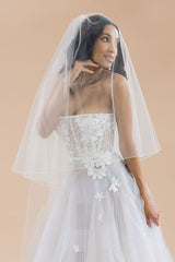 bodice of bride wearing Rosalynda pencil edge blusher veil over face 