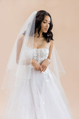 Bride looking down wearing pencil edge two tier cathedral wedding veil Rosalynda by Laura Jayne