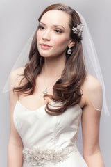 Pretty bride wearing cascade cut fingertip length tulle veil with crystal accents and silver metallic edging. Embrace Cascade Fingertip Veil. Laura Jayne Accessories Toronto. Handcrafted in Canada.