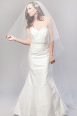 Full length image of classic bride wearing a minimalist chapel length veil with blusher over her face. Karina Crystal Border Chapel Veil made in Canada by Laura Jayne Associates Toronto.