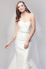 Modern minimalist bride wearing a fit and flare wedding dress with a sheer classic two tier chapel length veil with crystals. Karina Crystal Border Chapel Veil. Laura Jayne Associates Toronto. Handcrafted in Canada.