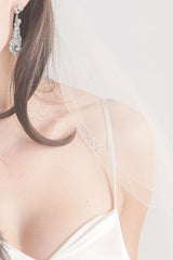 female shoulder draped with beaded veil