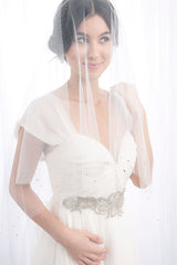 Romantic bride wearing a fingertip length blusher veil over her face. Lucille Crystal Fingertip Drop Veil by Laura Jayne. Handcrafted in Toronto, Canada.