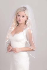 Modern classic bride wearing a simple two tier fingertip length veil with satin ribbon edging. Erin Ribbon Edge Fingertip Veil. Laura Jayne Accessories Toronto. Handcrafted in Canada.