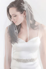 Bride with face turned to the side wearing Lavinia single tier beaded fingertip length veil by Laura Jayne. Handcrafted in Toronto, Canada.