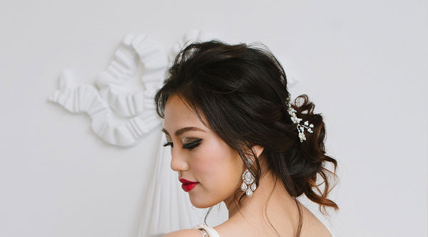 Woman with statement earrings and bridal headpiece