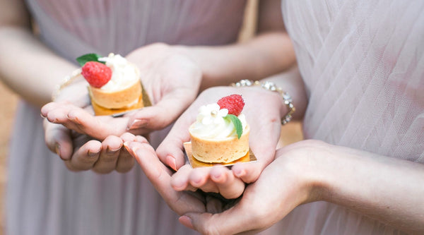 two bridesmaids holding cupcakes 