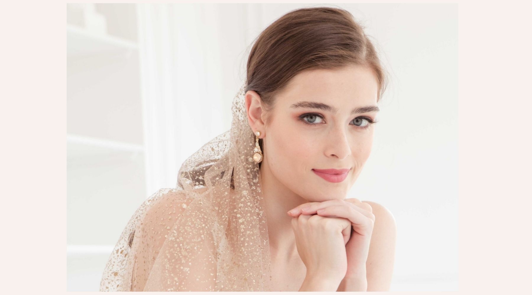 happy bride wearing a veil and earrings 