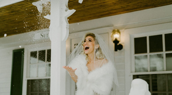 happy bride outdoors catching the snow 