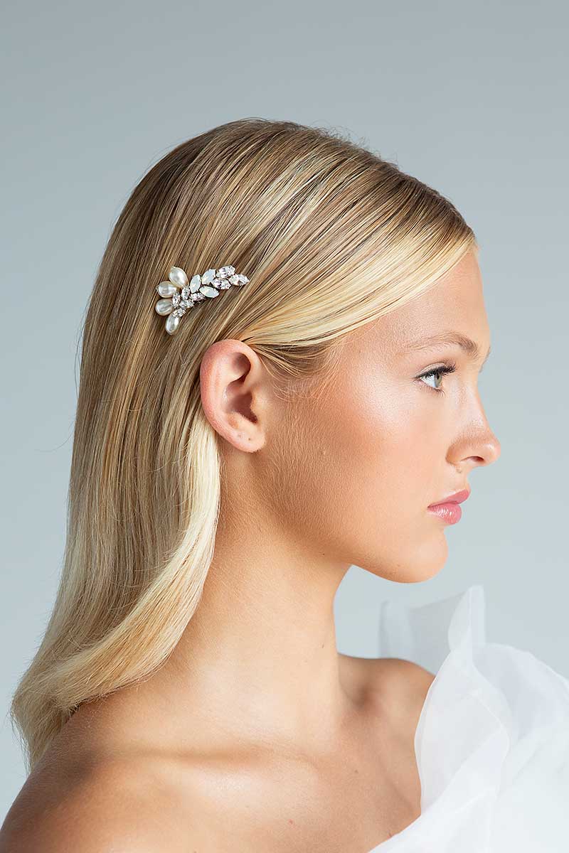 Head and shoulders profile of woman with hair tucked behind ear wearing cream pearl and opal crystal hair comb by Bridal Designer Laura Jayne Accessories 