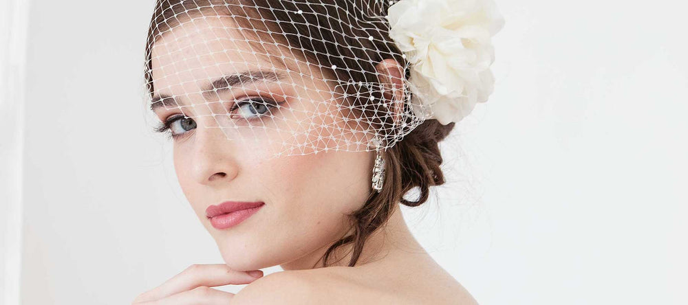 Woman wearing birdcage face veil and flower hair accessory from the Flora Collection by Laura Jayne Accessories