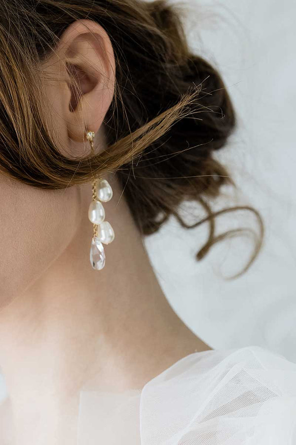 profile of woman wearing Laura Jayne modern pearl crystal chain drop earrings in gold champagne