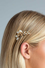 close up of rose gold crystal and pearl hair comb tucked behind woman's ear