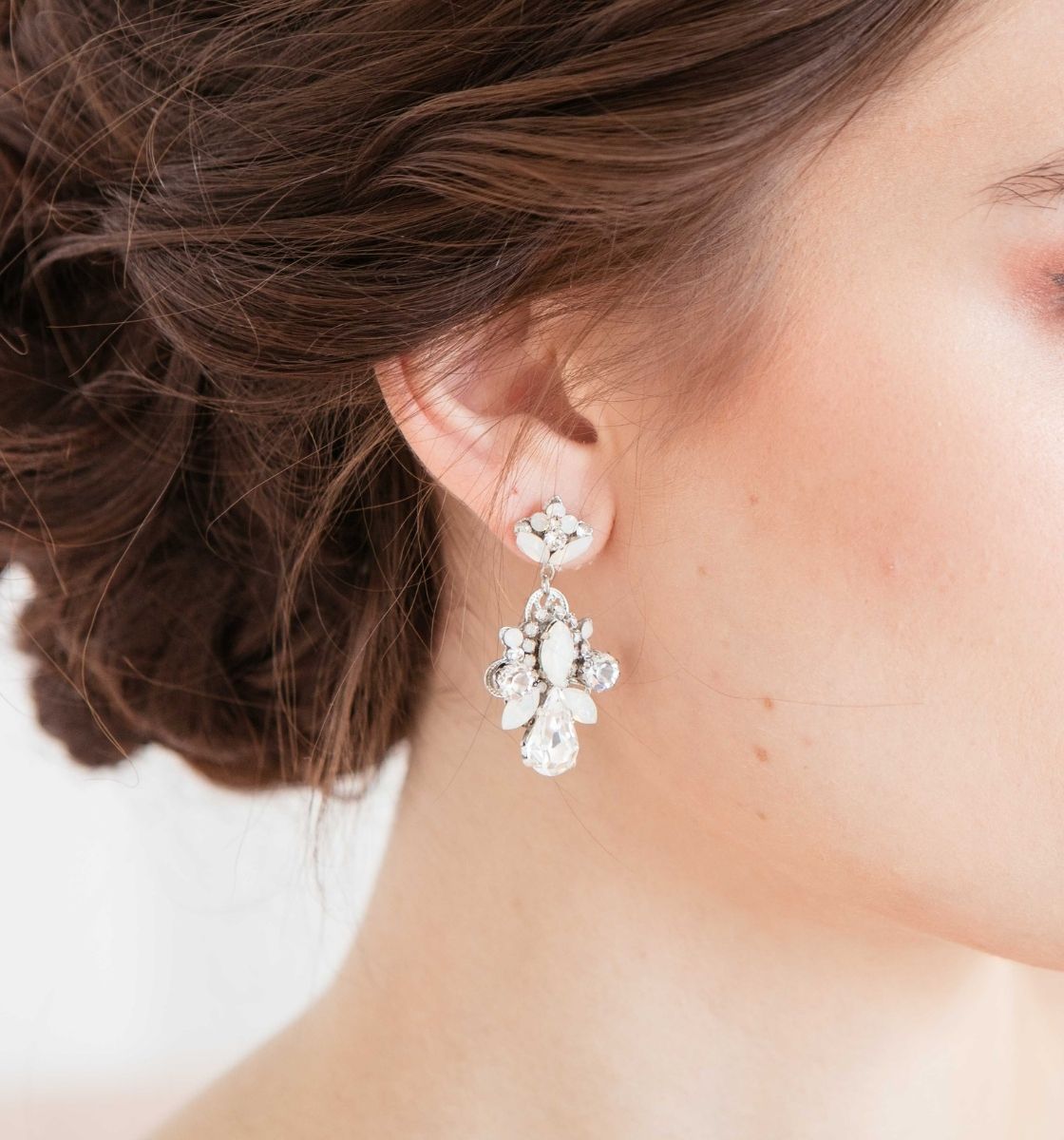 Close up of woman wearing opal crystal statement earrings by Laura Jayne Accessories