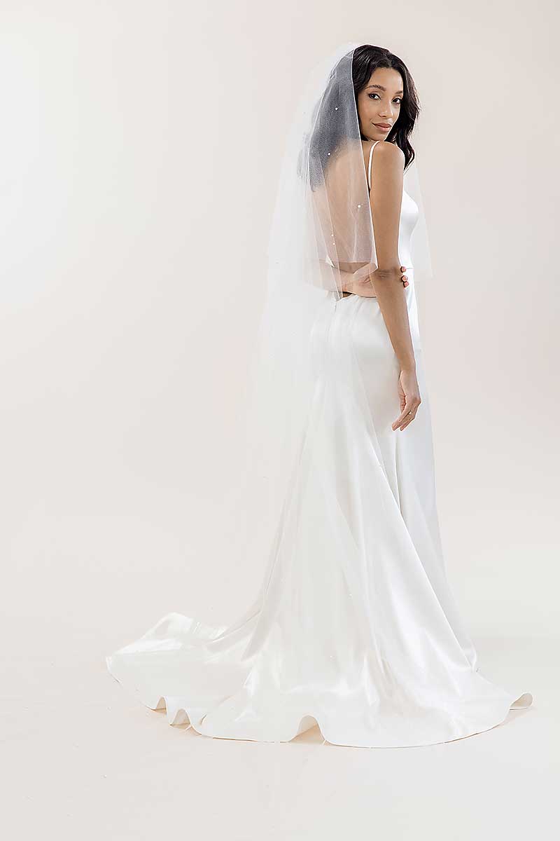 Back view of bride wearing pearl beaded drop cathedral length veil. Alayna Pearl Cathedral Veil by Laura Jayne Accessories. Made in Toronto, Canada.