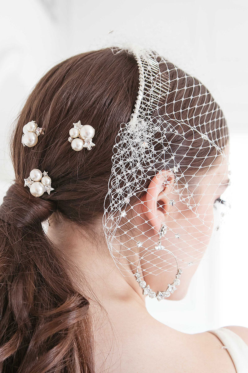Side back view of bride's head with pearl star hairpins and birdcage veil with crystal stars