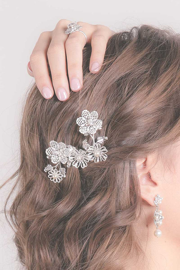 Close up of woman's hair with enameled blossom bridal hairvine comb