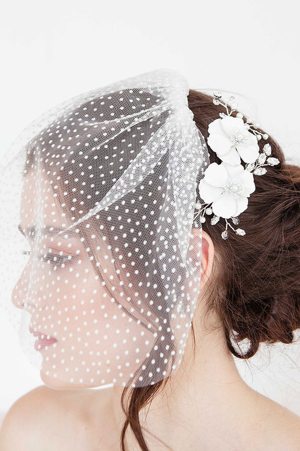 Profile of bride wearing Laura Jayne floral hair comb and dot face veil.