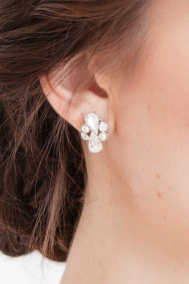 Close up of woman wearing pearl crystal post earring with pear focal stones.