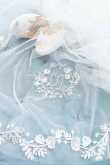 Close up of embroidered floral monogram crest and edging of statement cathedral length veil. Khrysia Monogram Cathedral Veil. Made in Canada by Laura Jayne Accessories Toronto. 